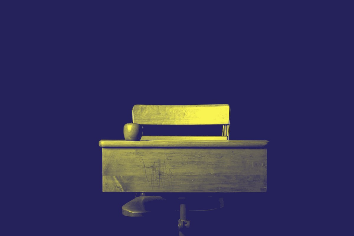 hiring-a-trainer an old-fashioned school desk and chair with an apple