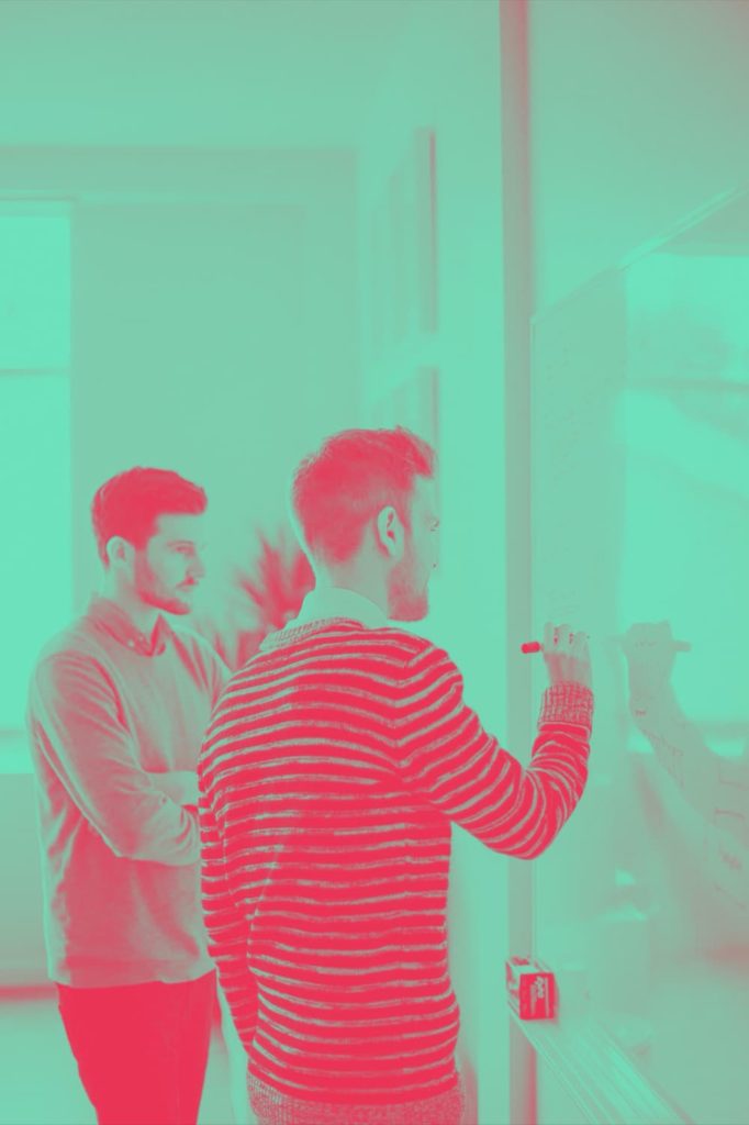2 men collecting ideas on a white board